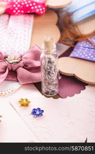 Scrapbooking craft materials and glass bottle with lavender. Scrap details