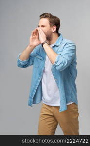 Screaming emotional angry man screaming standing over grey studio background.. Screaming emotional angry man screaming standing over grey studio background