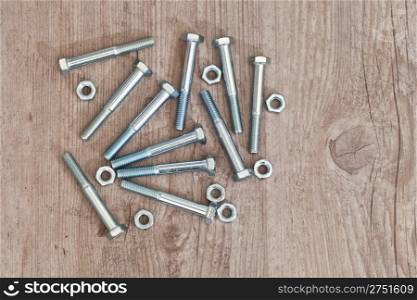 screws and bolts for carpentry on wooden background