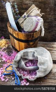 Scrub,brush,nail file in wooden tub on the background scattered with sea salt for Spa treatments.