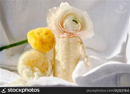 Scrub, loofah washcloth and organic sea sponge on the background of a terry bath towel with flowers.. Scrub, loofah washcloth and organic sea sponge on the towel.