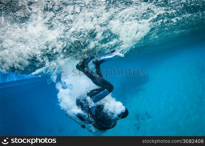 scuba diver enters the water from a boat and makes bubbles on the water surface