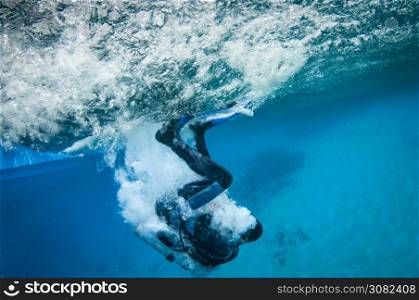 scuba diver enters the water from a boat and makes bubbles on the water surface