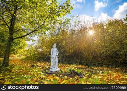 Sculpture in a park with colorful autumn leaves on the ground in the fall