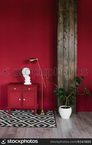 Sculpture of a head on a red chest of drawers, a houseplant in a white pot in a stylish living room