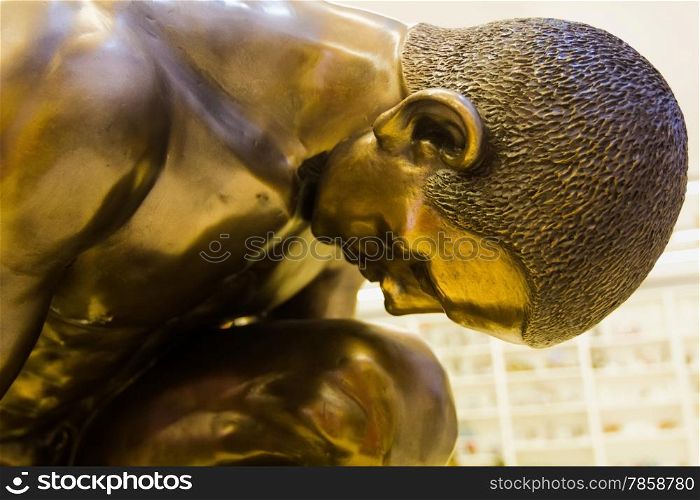sculpture of a person crouching in bronze