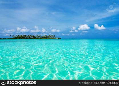 Sea and blue sky. Blue sea water and sky with white fluffy clouds. Horizontal background of blue sea. Tropical landscape