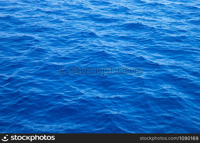 Sea background . Blue water with sun reflections