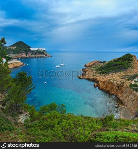 Sea bay summer view with conifer trees in front. Costa Brava, Catalonia, Spain. Three shots stitch image.