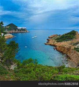 Sea bay summer view with conifer trees in front. Costa Brava, Catalonia, Spain. Three shots stitch image.