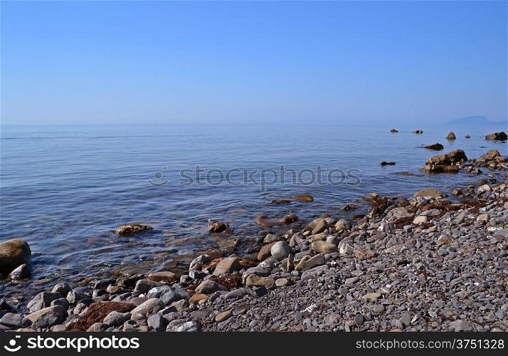 Sea beach of pebbles and stones near the calm sea