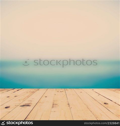sea blurred and wood table for space with vintage tone.