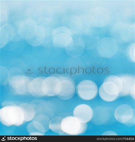 Sea blurred background with patches of light from the sun.