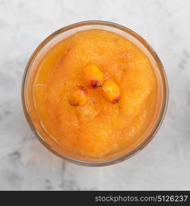 Sea buckthorn smoothie. Sea buckthorn smoothie on a white concrete background. Square cropping