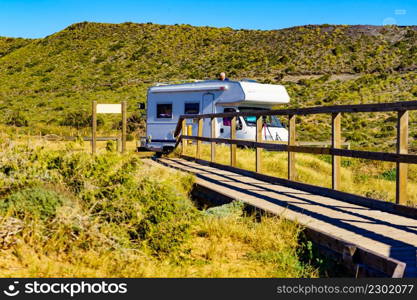 Sea coast view with wooden path and camper car rv camping on beach. Spain Murcia region, Calblanque Regional Park.. Wooden path on beach with camper camping on coast