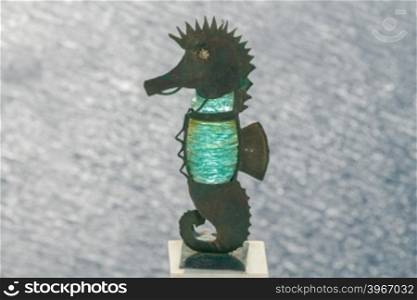 Sea horse made of metal and green glass on the parapet of the embankment in Fira. Greece. Santorini.. Metal statue of seahorse in Fira.