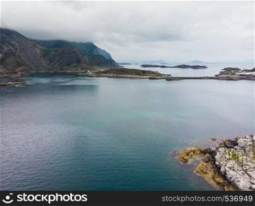 Sea landscape with islets among the waters of fjord Vjestfjord, Lofoten islands, Henningsvaer region, Norway. Hazy day, overcast weather.. Aerial view. Lofoten islands landscape, Norway
