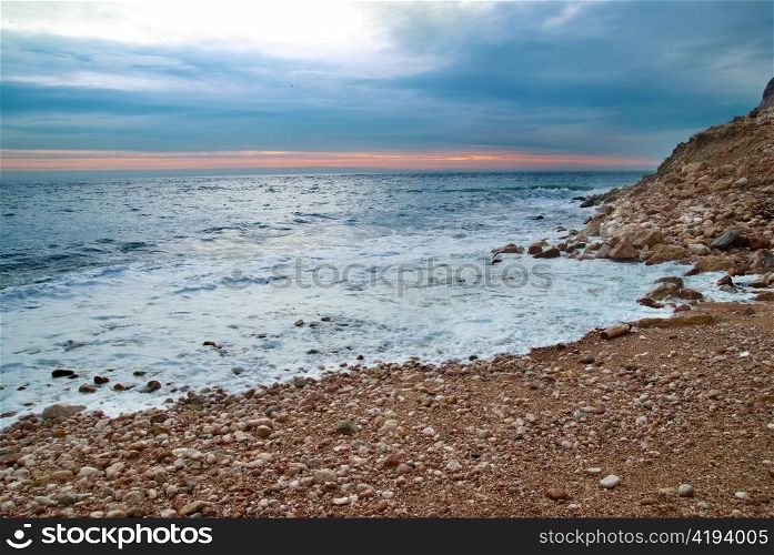 Sea landscape with waves on the beach against sunset