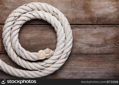 Sea rope with shell on wooden background