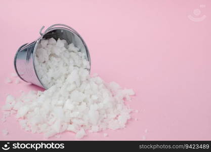 Sea salt in a tin bucket on pink background for seasoning or preserving food