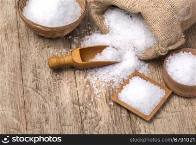sea salt in the bag and with wooden spoon on wooden background