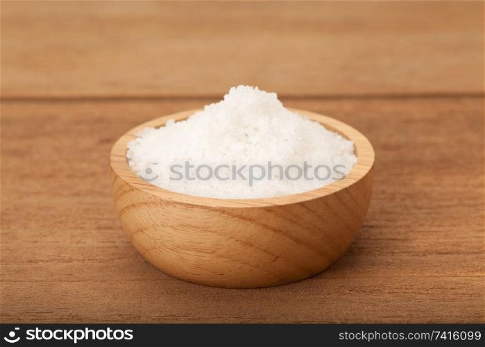 Sea salt in wooden bowl on wood background