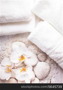 Sea salt, rebbles with orchids and white towels, spa concept