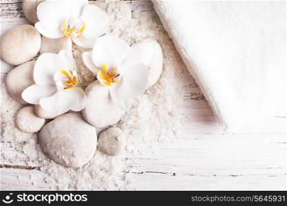 Sea salt, rebbles with orchids and white towels, spa concept