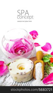 Sea salt, rose, soap and a burning candle on a white table