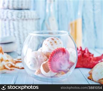 sea shells in glass bowl and on a table
