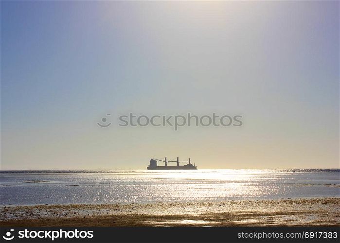 Sea ship sails. Sea ship sails along the shore at sun light