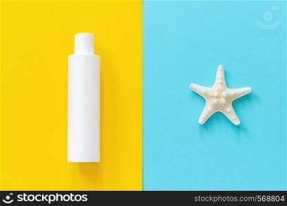 Sea starfish and white bottle of sunscreen on yellow and blue paper background. Mock up Template for lettering, text or your design Creative Top View.. Sea starfish and white bottle of sunscreen on yellow and blue paper background. Mock up Template for lettering, text or your design Creative Top View