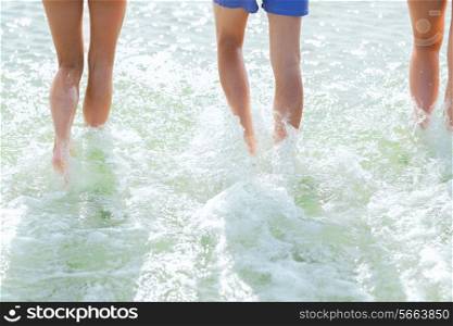 sea, summer vacation, holidays and people concept - close up of human legs walking on summer beach