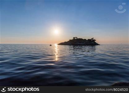 Sea sunset with island and low sun