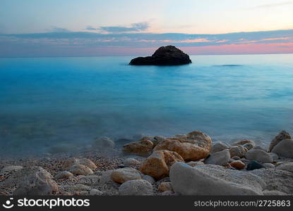 Sea sunset with rock and misty water