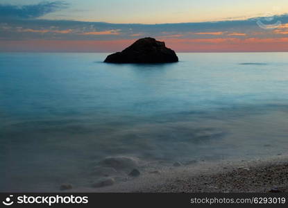 Sea sunset with rock and misty water