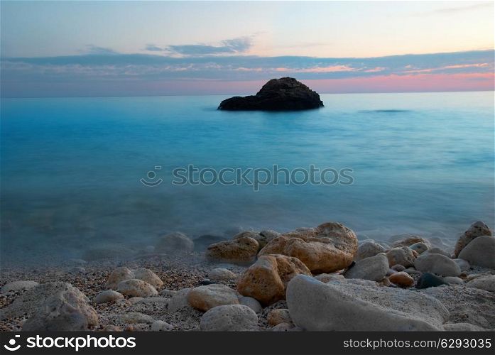 Sea sunset with rock and misty water