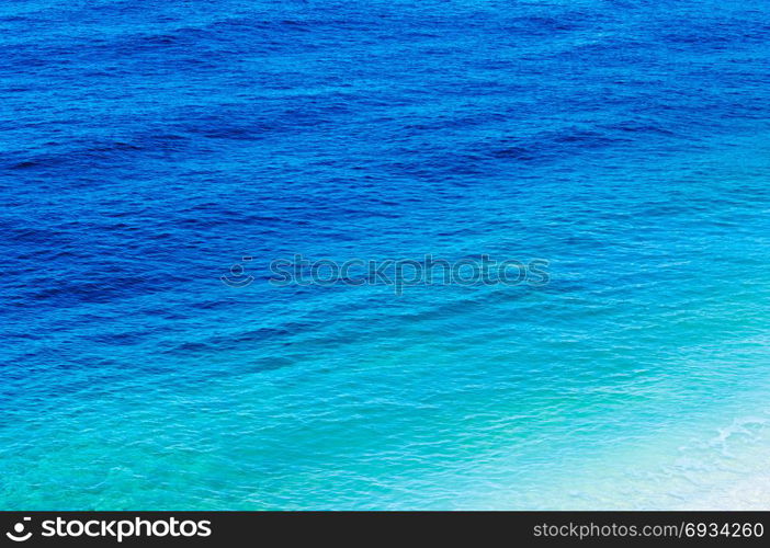 Sea view at a pebble beach, little waves, turquoise water, tranquil scene