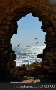 Sea view through the doorway of a ruined house