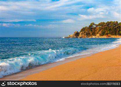 Sea waves and sand main beach at popular holiday resort Lloret de Mar on Costa Brava in the morning , Catalunya, Spain