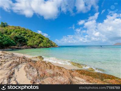 Sea waves on sand beach water and coast seascape rocky coast / View of beautiful tropical landscape beach sea island with ocean blue sky and resort background in Thailand summer beach vacation