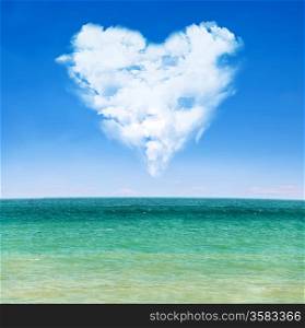 sea waves over blue sky with clouds in shape of heart