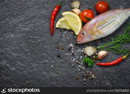 Seafood fish plate ocean gourmet dinner fresh raw fish with herbs and spices on dark background