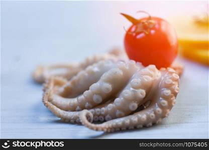 Seafood fresh squid octopus raw and tomato on white wooden background