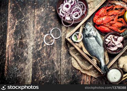 Seafood in an old tray. On a wooden background.. Seafood in an old tray.