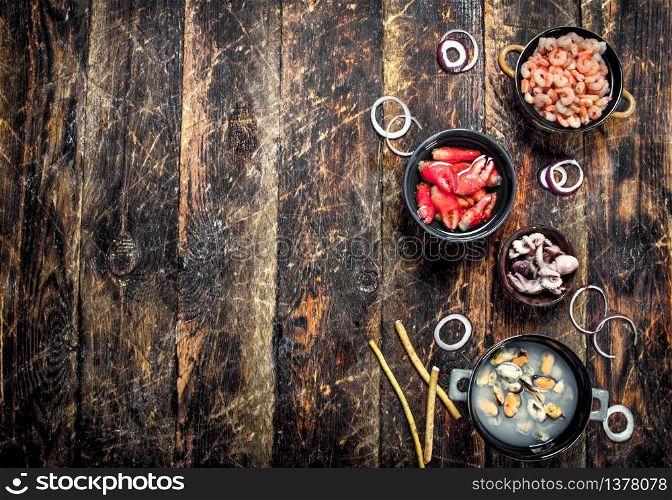 Seafood in bowls. On a wooden background.. Seafood in bowls.