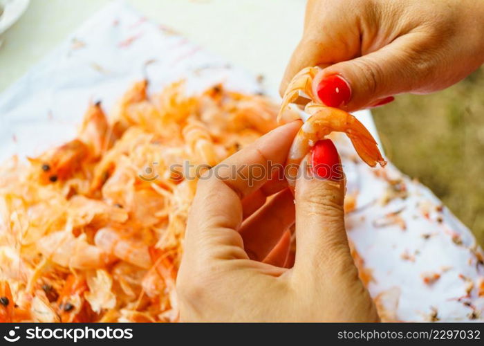 Seafood, ocean food. Female hands peeling raw fresh shrimps. Preparing for cooking prawn.. Hand peeling raw fresh shrimp.