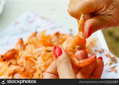 Seafood, ocean food. Female hands peeling raw fresh shrimps. Preparing for cooking prawn.. Hand peeling raw fresh shrimp.
