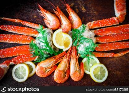 seafood on black. crab and shrimps on dark background. delicious cooked shrimp with an accompaniment of crab legs
