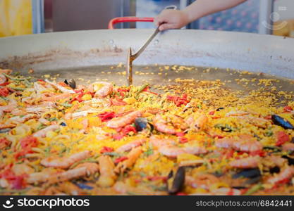 Seafood paella in a paella pan at a street food market Traditional Spanish paella with seafood and chicken.